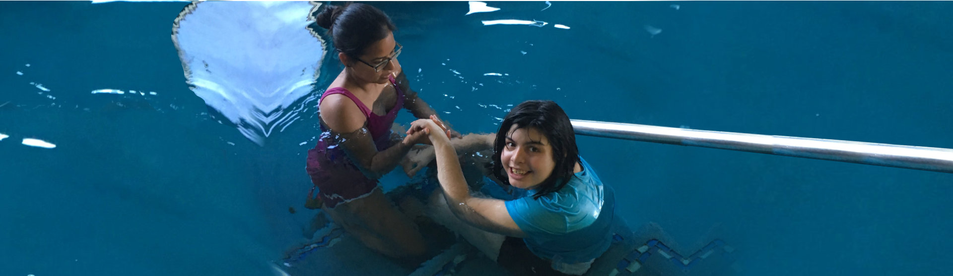 woman teaching a young girl to swim